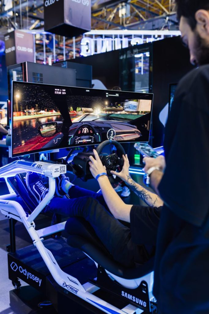 A person confidently navigates a virtual race simulator at an indoor gaming event.